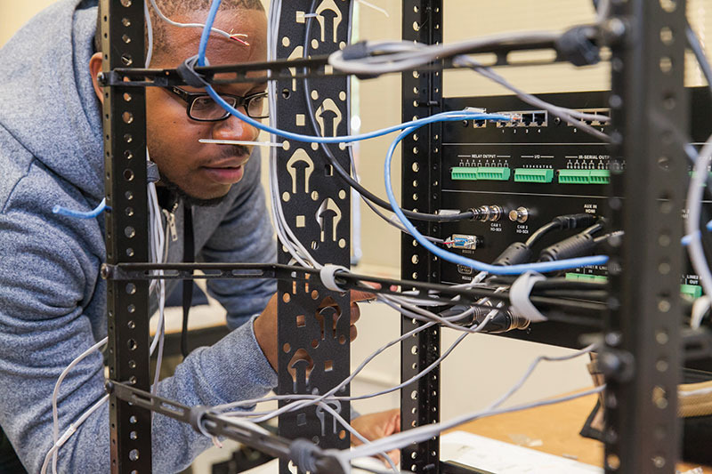 Man looking at installation cables | AVIXA