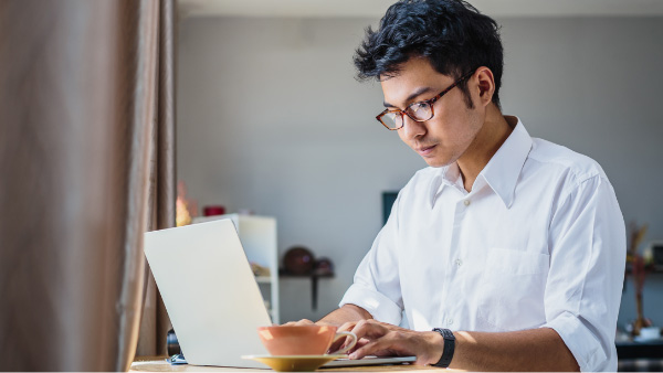 Man looking at his laptop computer | AVIXA