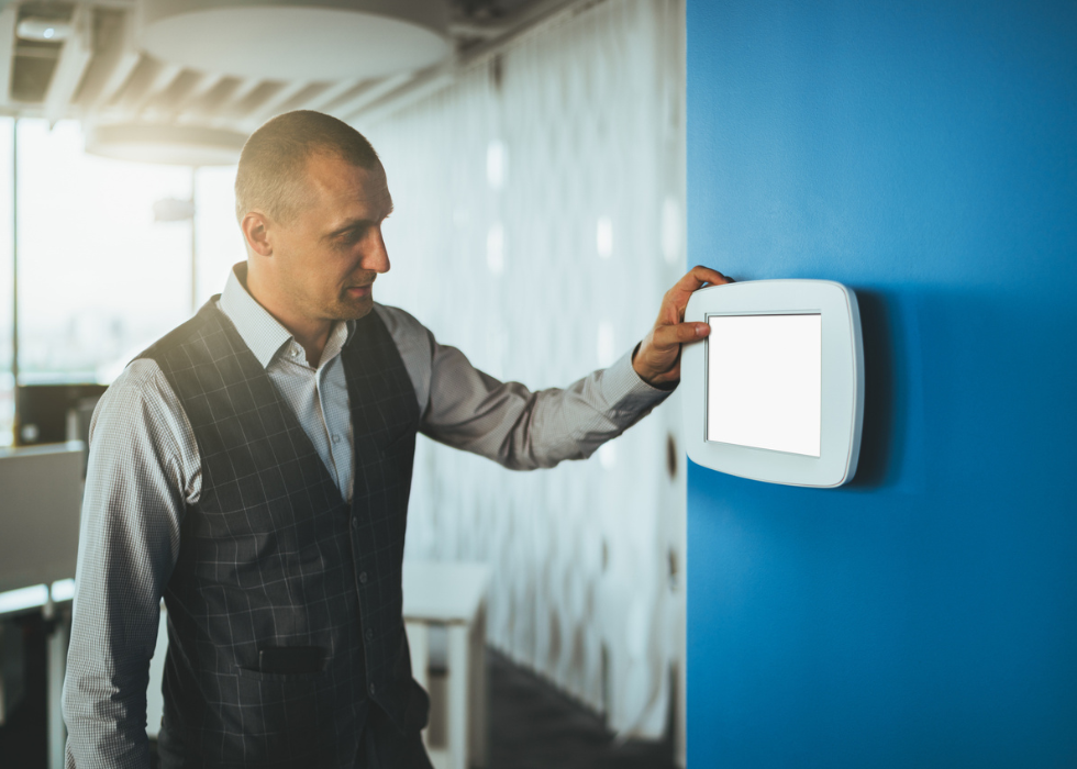 Man controlling lighting in office