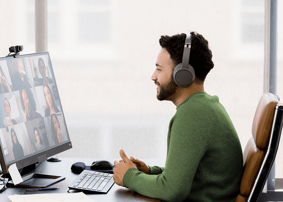 Man in Video Conference Meeting Using Wireless Headphones and Laptop