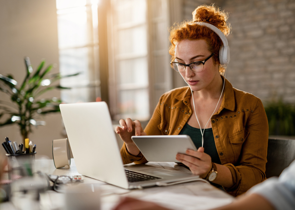 woman with headphones working on tablet