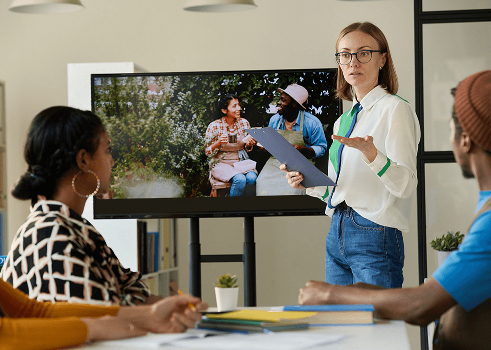 box_of_broadcasts Young female teacher showing videos to group of students
