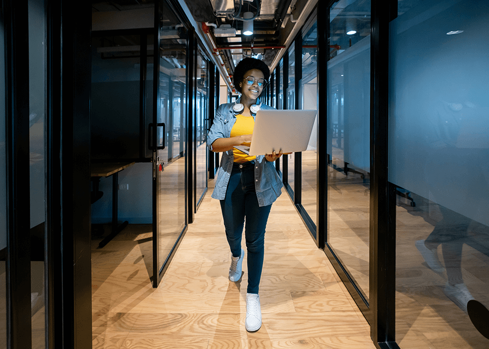IoT_Security_solutions Woman IT manager walking office hall with laptop