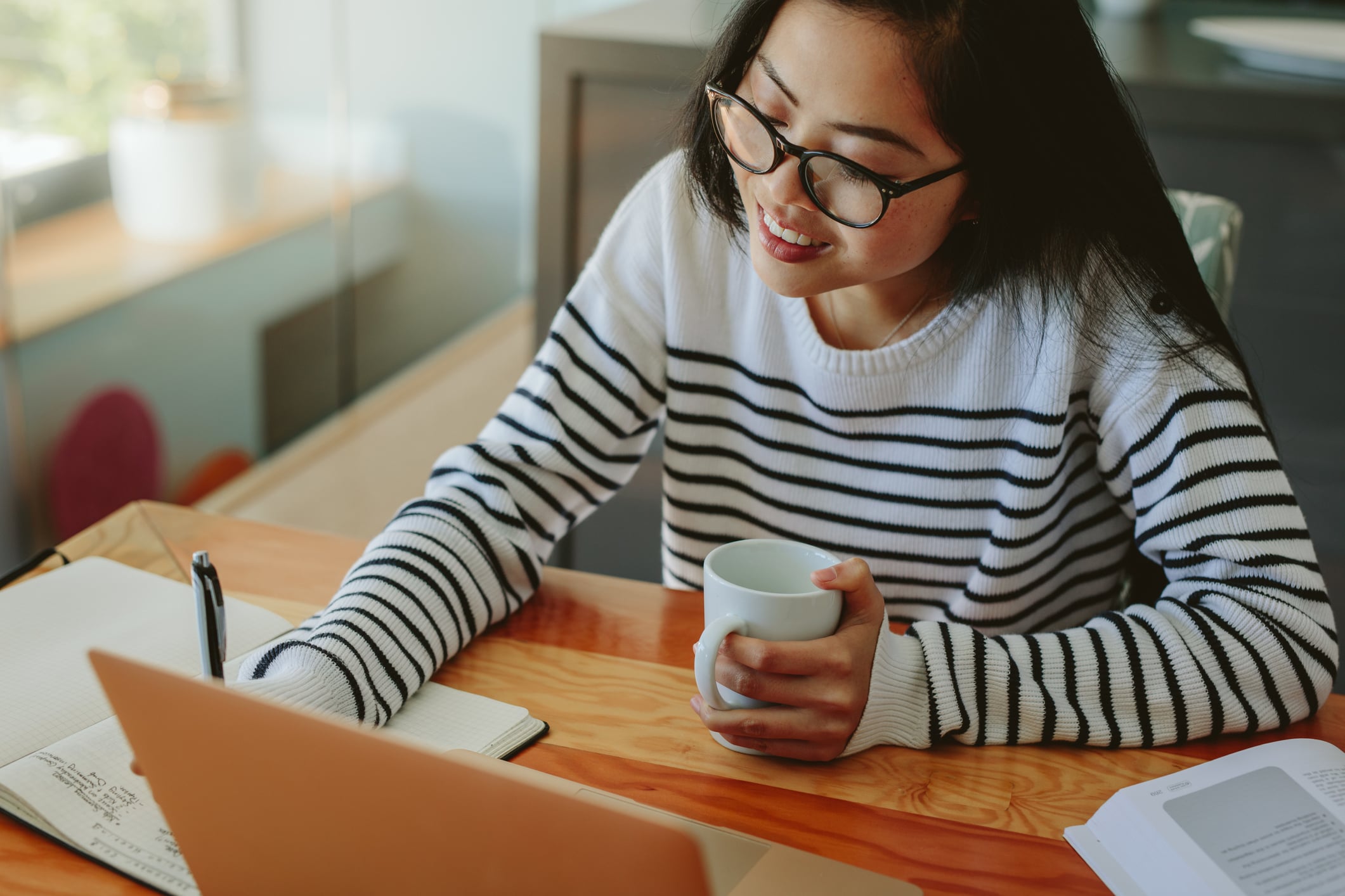 woman taking notes at a webinar