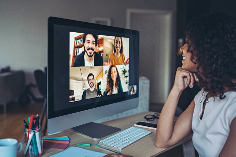 Photo of person looking at computer screen with video conference participants | AVIXA