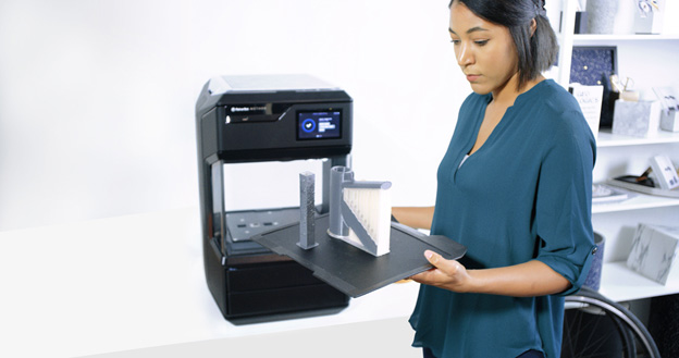 Woman experimenting with 3D printer at Makerbot | AVIXA