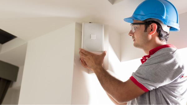 Man in hardhat setting up electornics | AVIXA