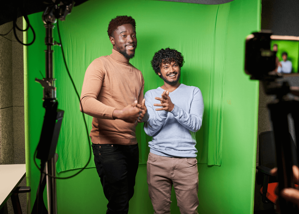 portable_green_screen Two men standing in front of a portable green screen