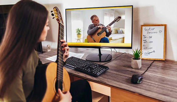 Student getting virtual guitar lessons | AVIXA